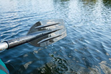 Su damlalarının üzerinde siyah bir plastik kürek. yakın çekim kürekleri