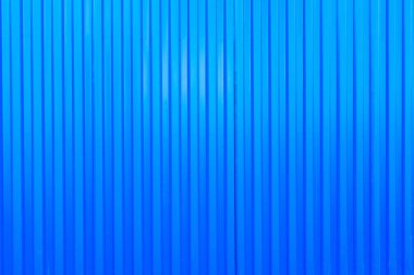 Mavi metal çit yüzeyi, kıvrımlı çarşaf. Metal bir levhada dikey satırlar