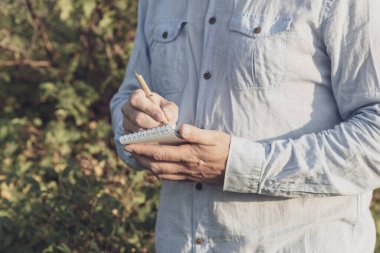Yazar doğada dururken düşüncelerini yazar. Bilim adamı botanikçi not alıyor