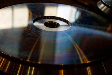 Çevresinde yansıtıcı çizgiler olan metal disk, metal yüzeyinde gökkuşağı parıltısı