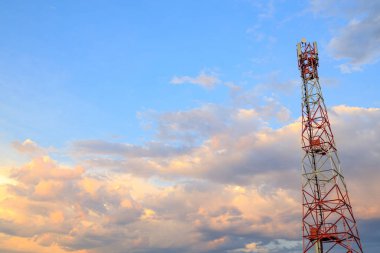 Çerçevenin sağ tarafından taşınabilir iletişim için metal kule ile kümülüs bulutlu mavi gökyüzünün arka planı karşı karşıya