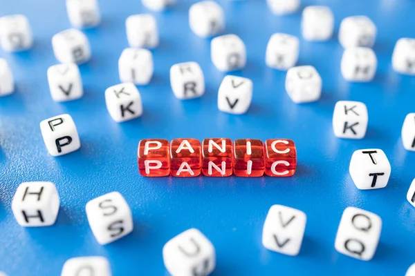 red cubes with the word panic around them white cubes with letters, the inscription panic from toy cubes