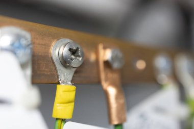 Topraklama kablolarının zemin çubuğuna tutturulduğu yakın plan