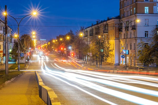 Rusya, Kamensk-Uralsky, 4 Ekim 2019 gece küçük bir kasabanın caddesinde giden arabaların ışıkları. Sokakta far izleri var.