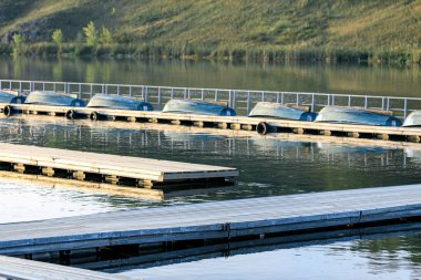 Suya ahşap iskele monte edilmiş ve tekneler kiralanmak ve kiralanmak için sıraya dizilmiş, bir yaz günü nehir.