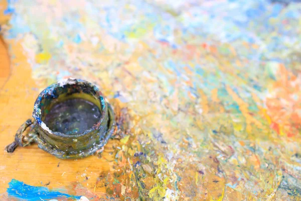 out of focus paint jar and paint mixing board after artist\'s work