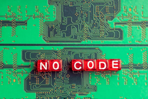 no code inscription on a green microcircuit, red cubes on green simplification of programming