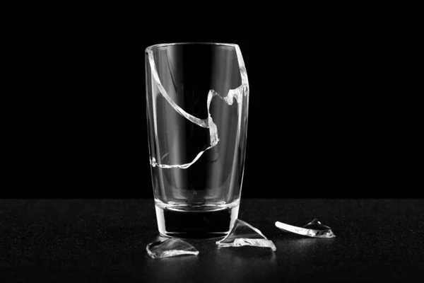 an empty broken glass without liquid, fragments of cracks along the body. alcoholism difficulties in life