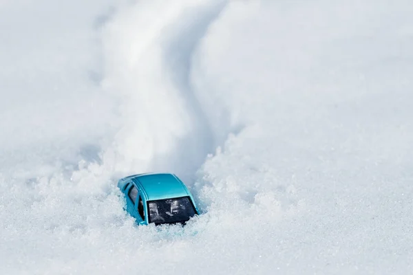 Ayak izleri ve karda bir araba, büyük bir kar yığınına sıkışmış bir araba. Yolda kar yağışı
