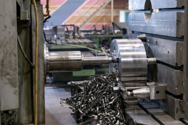 Eski bir üretimdeki eski bir makinede sondaj işlemi, sondaj ve soğutma. Bir sürü talaş.