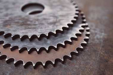 Metal bir yüzeyin arka planında üç büyük metal dişli. çelik ürünleri