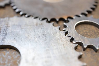 Büyük ve küçük dişliler çelik yüzeydeki bazı mekanizmalarla etkileşir.