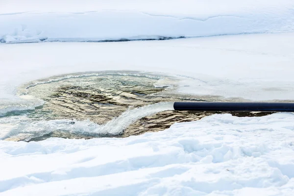 Ufer Eines Zugefrorenen Flusses Fließt Winter Ein Schwarzes Rohr Heraus — Stockfoto