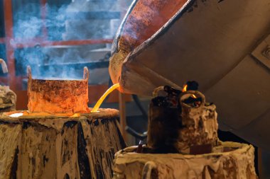 Dökümhanede, sıvı erimiş metali kalıba dökme işlemi, küf dumanından çıkar.