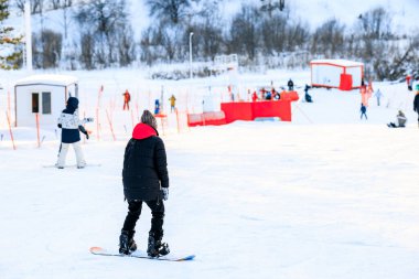 Snowboard sporcusu küçük bir tepede snowboard yapmayı öğreniyor. Kamensk, Rusya - 30 Ocak 2021