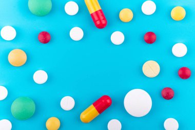 İlaçlar ve farklı renklerde haplar yazıtlar için boş alanın ortasındaki mavi arka planda. Uyuşturucu konusunu kapsamak için