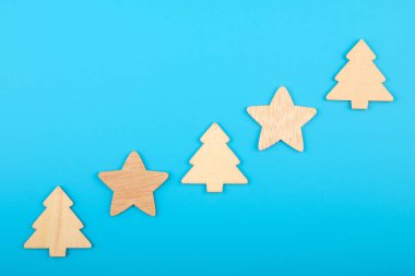 Oyulmuş ahşap heykelcikler çapraz olarak yukarı doğru sıralanır. arkaplan mavi