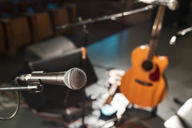 Müzisyenler olmadan boş bir sahnede elektrikli mikrofon. Konserden önce sahneye çıkmak için müzik ekipmanı