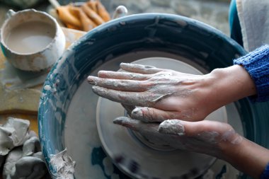 Çömlekçi çarkı üzerinde çalışıyorum. Çömlekçi elleri iş başında. kil ürünlerin oluşturulması