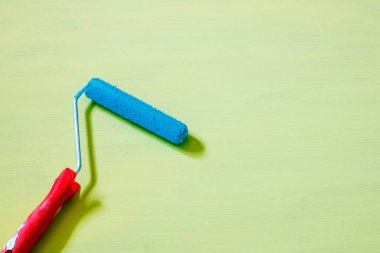 Boyalı arka planda bir boya silindiri. renk karşıtlığı