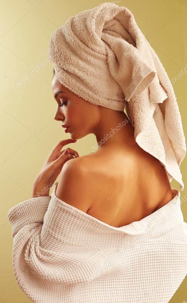 Портрет молодой красивой женщины в халате и полотенце на гол