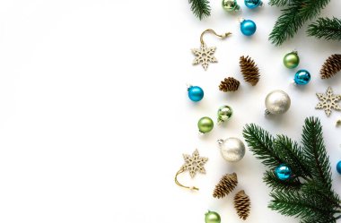Tatil süslemeleri. Beyaz arkaplanda Noel oyuncakları, koniler ve köknar dalları, metin için boşluk