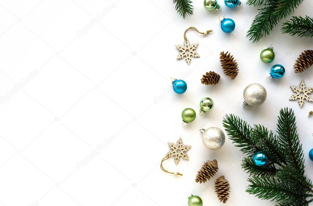 Holiday flat lay of decorations. Christmas toys, cones and fir branches on white background, space for text