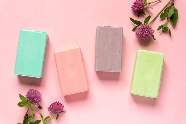 Flat lay of various natural soap bars with clover flowers on pink background, top view Royalty Free Φωτογραφίες Αρχείου