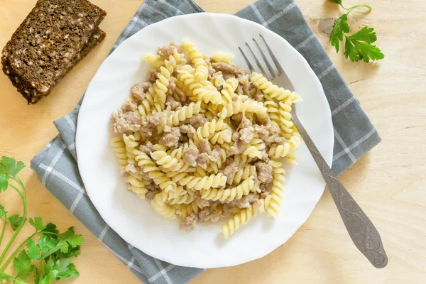 Beyaz tabakta kıymalı Fusilli makarna, üst manzara.