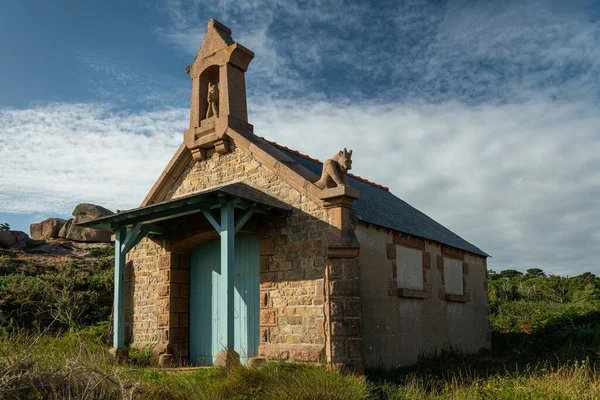 Old house made of stone near lighthouse of Ploumanach (Brittany, France), cloudy day in summer