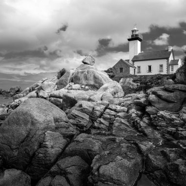 Deniz feneri De Pontusval yazın bulutlu bir günde, plaj ve ilginç kayalar (Brittany, Fransa)