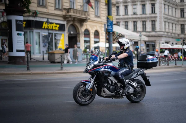 Vienna, Austria - June 19, 2021: Policeman with motorcycle on Wiener Ringstrasse during Vienna Pride