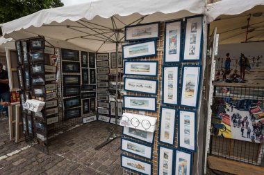 Saint-Malo, France - August 11, 2018: A street stall displays small pictures in Saint-Malo France on a cloudy summer day.