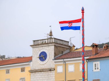 Cres, Hırvatistan - 29 Mart 2024: İlkbahar akşamı Cres Hırvatistan 'daki çan kulesinin önünde bir Hırvat bayrağı dikiliyor.