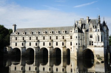 Chenonceaux, Fransa - 7 Ağustos 2013: Chateau de Chenonceau dış görünüş ve yaz günışığında nehir yansımaları manzaralı mimari