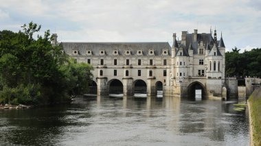 Chenonceaux, Fransa - 7 Ağustos 2013: Chenonceau Şatosu nehir kemerleri ve güneşli yaz gökyüzünün altında yansımaları tarihi mimariyi gösteriyor