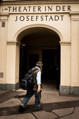 Viyana, Avusturya - 4 Ağustos 2020: Sırt çantalı bir adam yaz günü Josefstadt tiyatrosu yakınlarında yürüyor
