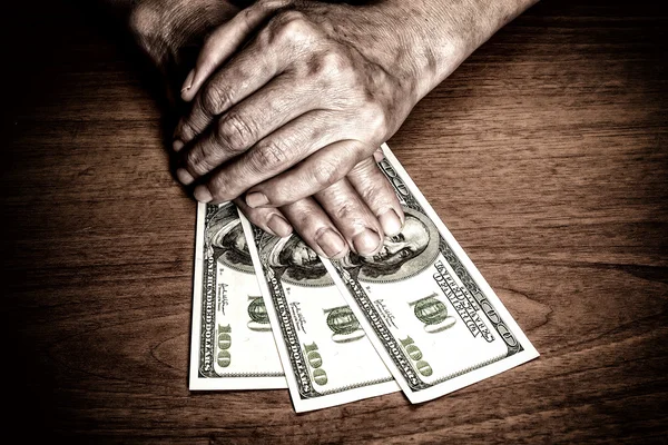 Oude man de hand met een bankbiljet — Stockfoto