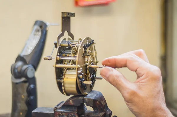 Hombre fijando un viejo mecanismo de reloj — Foto de Stock