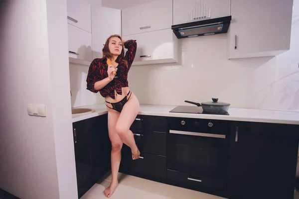 Close-up gedeeltelijke weergave van naakte jonge vrouw in schort koken thuis. — Stockfoto