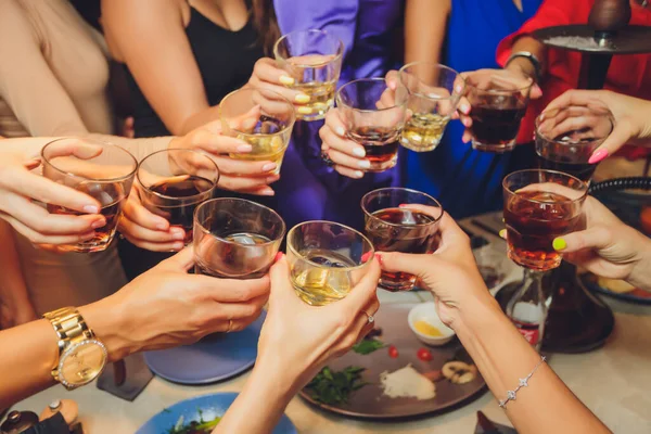 Close up shot of group of people clinking glasses with wine or champagne in front of bokeh background. older people hands. — Stock Photo, Image