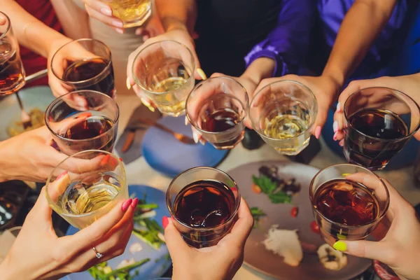 Close up shot of group of people clinking glasses with wine or champagne in front of bokeh background. older people hands. — Stock Photo, Image