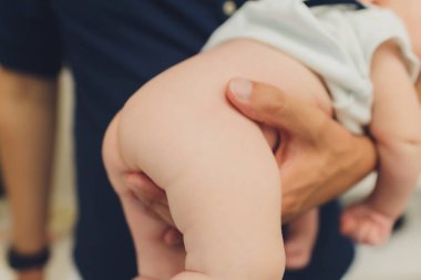 Anne bebek bezini değiştirirken, bebek odasında sırtüstü yatarken bebeğin altını değiştiriyor. Bebek hijyeni, ıslak bir peçete..