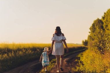 Güzel genç anne ve kızı buğday tarlasında eğleniyorlar..
