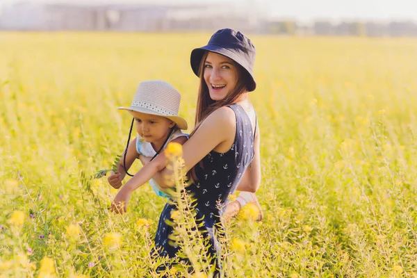 Bella giovane madre e sua figlia divertirsi al campo di grano. — Foto Stock