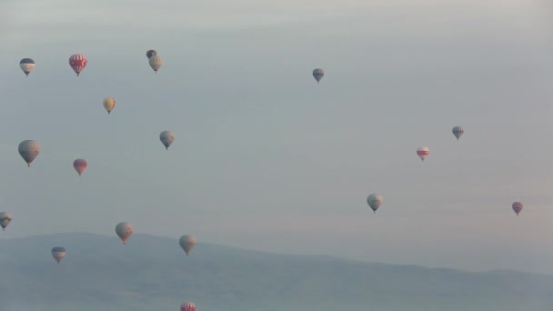 Kapadokya Türkiye 'de kayaların üzerinde uçan sıcak hava balonu. — Stok video