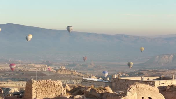 У Каппадокії (Туреччина) над гірським ландшафтом пролітає повітряна куля.. — стокове відео