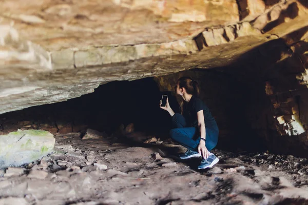 Jovem mulher de pé na frente de uma rocha de pedra ao ar livre. — Fotografia de Stock