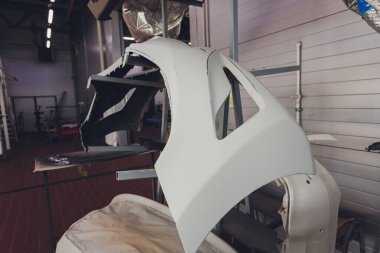 Araba tamir atölyesinde boya yaptıktan sonra araba tamponu parçası raflara monte edildi.