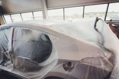 Kırık bir araba renginde gümüş, plastik bir kaplamayla kaplanmış. Araba kazadan sonra polietilen ile kaplandı. Çok büyük bir borç..